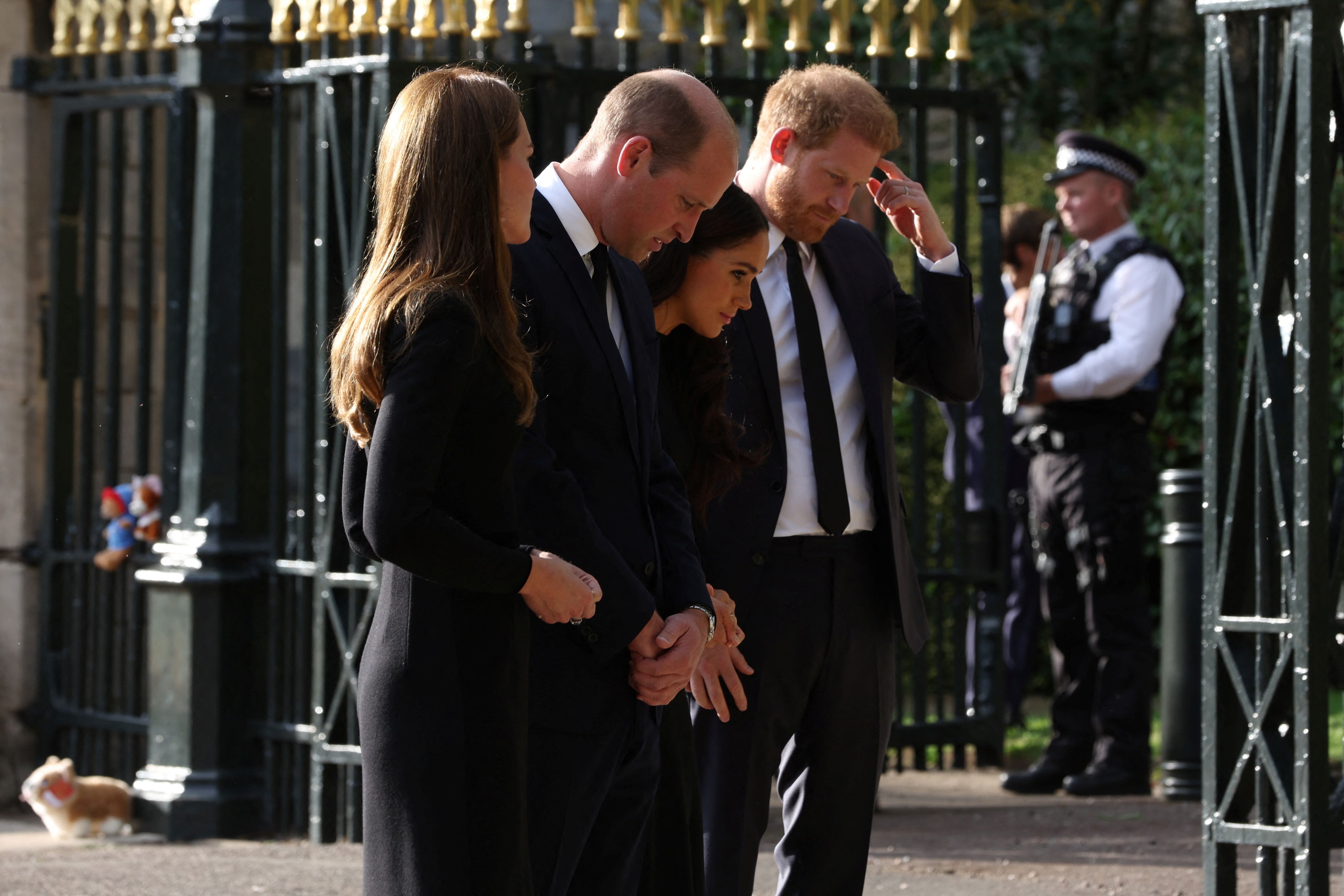 Britain's William, Prince of Wales, Catherine, Princess of Wales, Britain's Prince Harry and Meghan, the Duchess of Sussex, look at floral tributes as they walk outside Windsor Castle, following the passing of Britain's Queen Elizabeth, in Windsor, Britain, September 10, 2022. REUTERS/Paul Childs