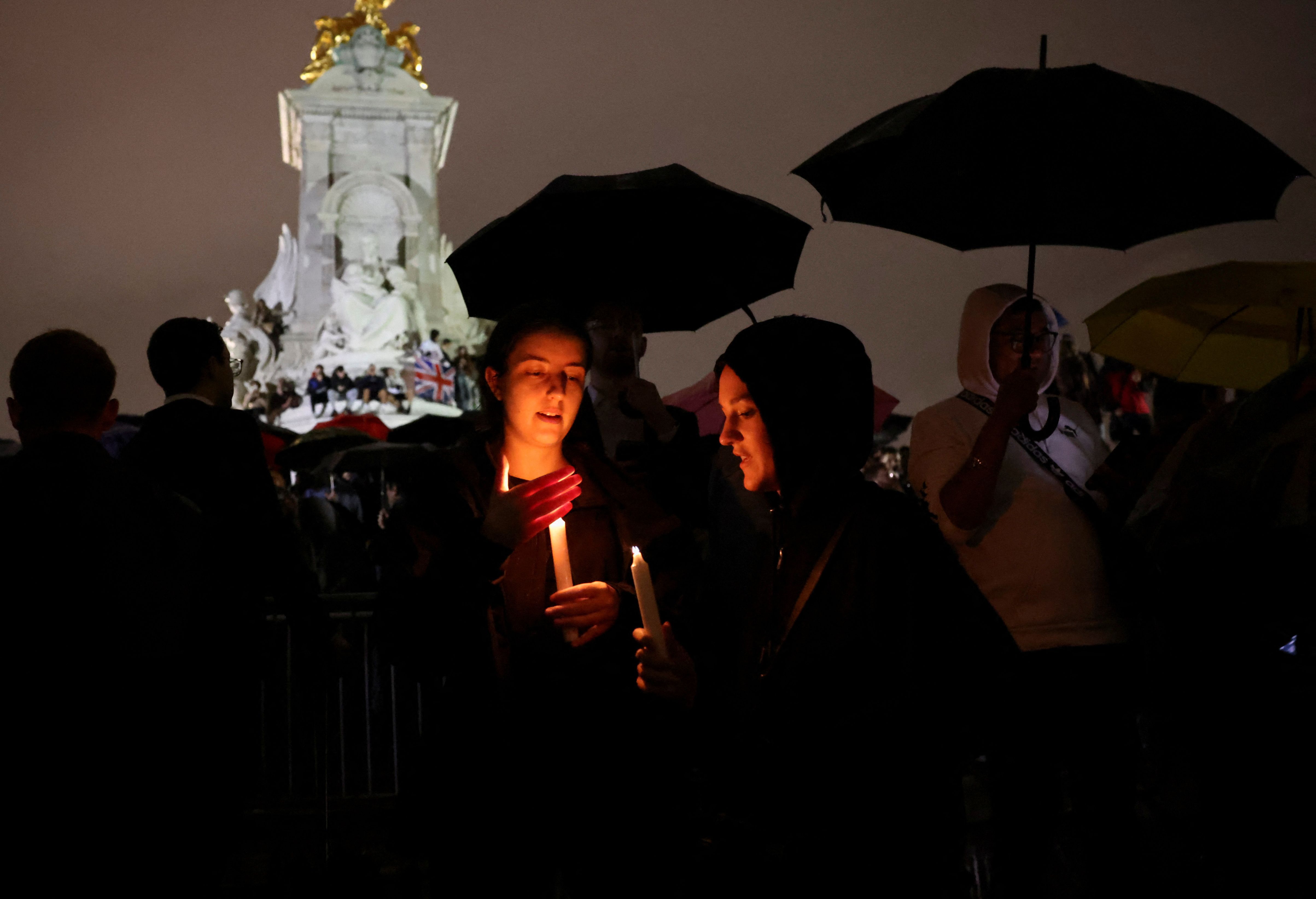 Dos jóvenes sostienen una vela en medio de los homenajes a la reina Isabel (REUTERS/Henry Nicholls)