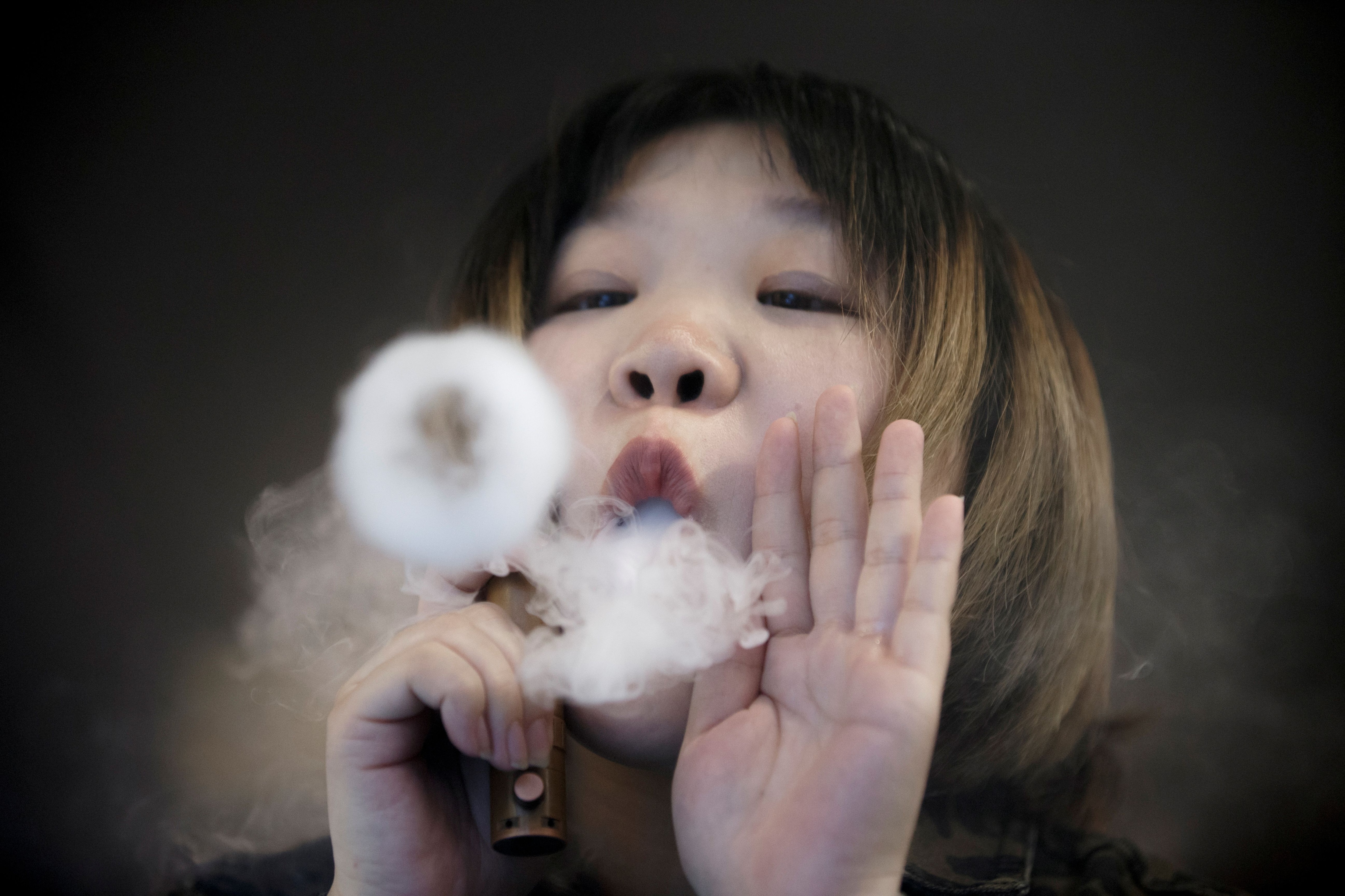 FILE PHOTO: A saleswoman demonstrates vaping at the Vape Shop that sells e-cigarette products in Beijing, China January 30, 2019. REUTERS/Thomas Peter/File Photo