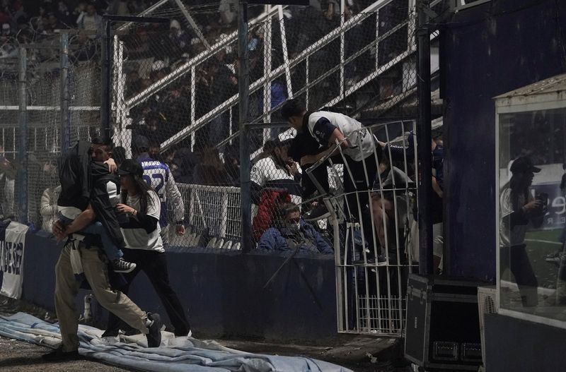 Caos en el estadio de Gimnasia y Esgrima La Plata mientras los hinchas saltaban al campo de juego para huir de los gases lacrimógenos (Reuters)
