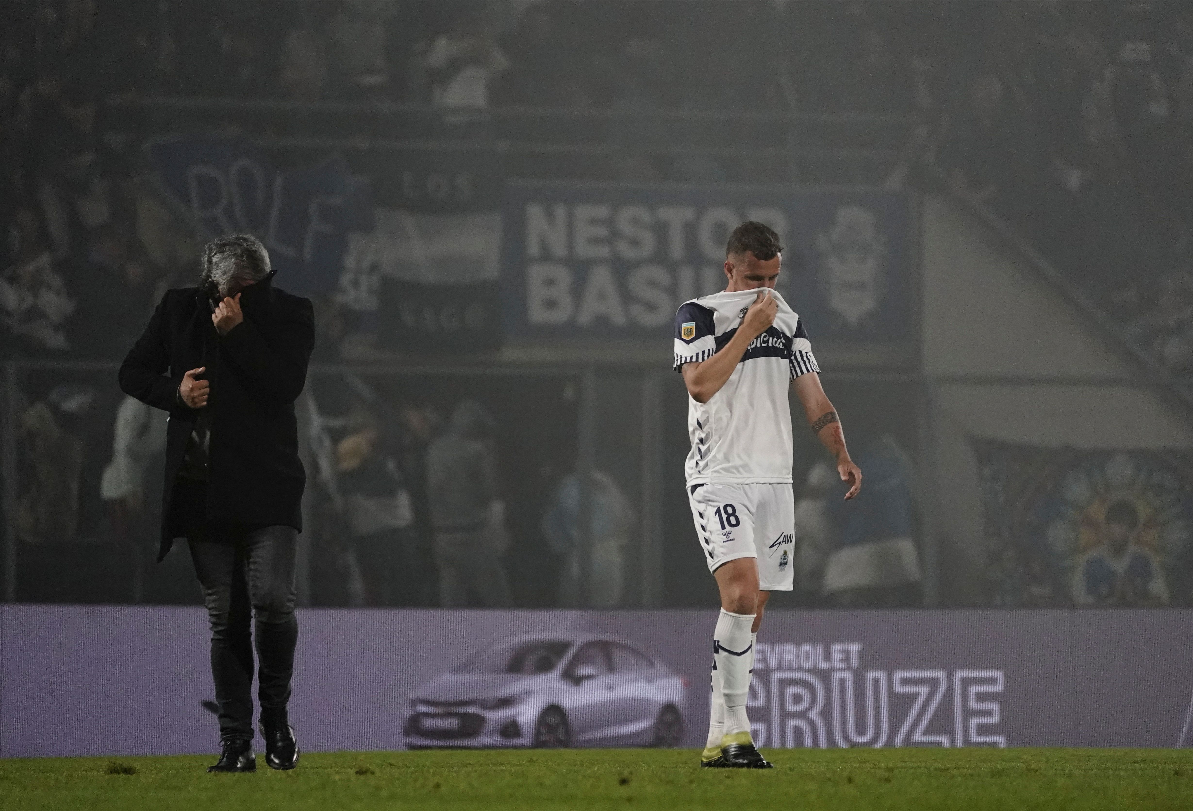 El jugador Nicolas Colazo y el DT de Gimnasia Nestor Gorosito en medio de los gases (Reuters)