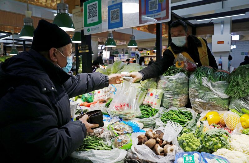 FOTO DE ARCHIVO: Personas con mascarillas en un mercado, tras los nuevos casos de la enfermedad del coronavirus (COVID-19) en el país, en Pekín, China, 11 de enero de 2021. REUTERS/Tingshu Wang