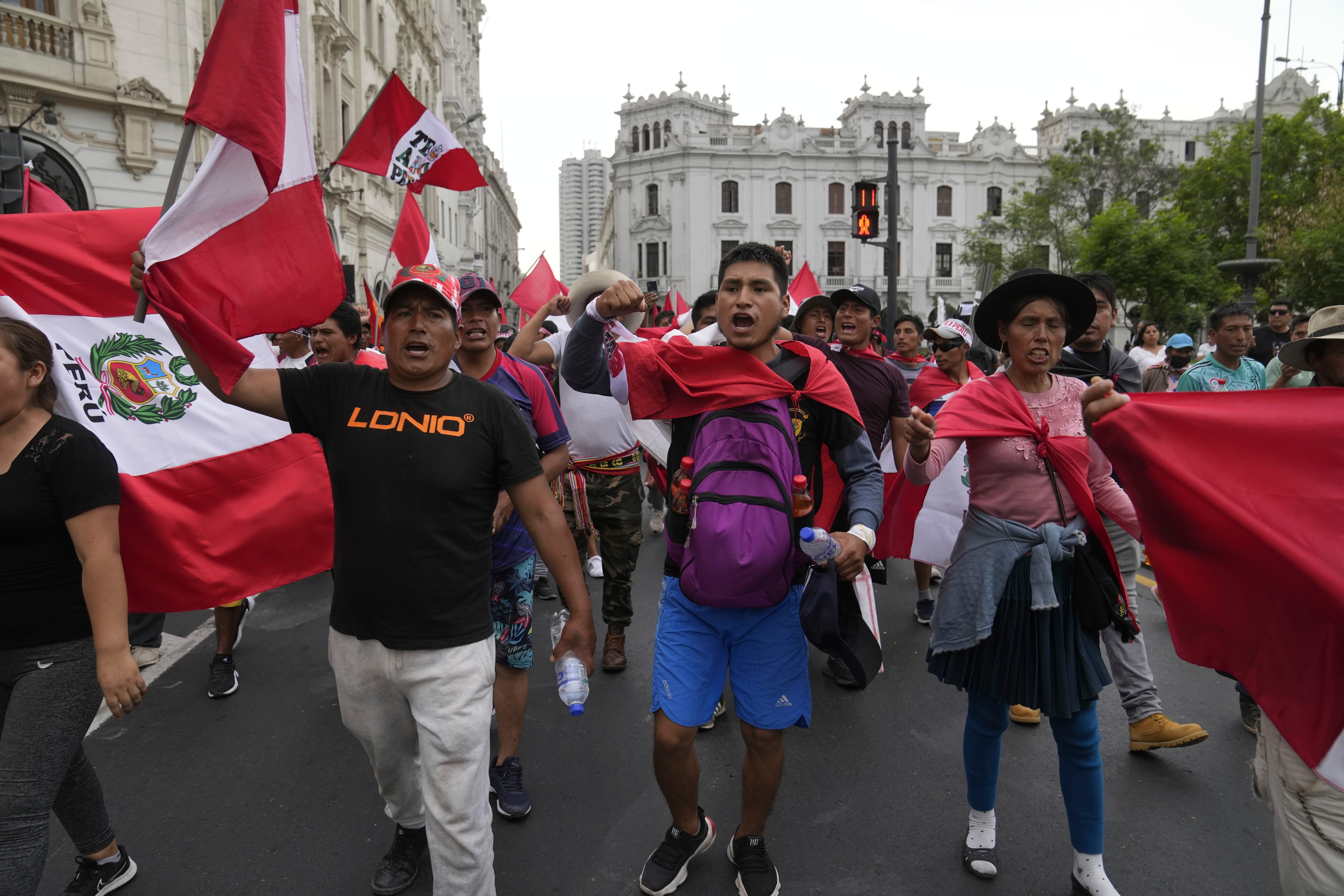 Manifestantes antigobierno que viajaron a la capital desde otras partes del país se enfrentan a una línea de policías antimotines en una marcha contra la presidenta peruana Dina Boluarte en Lima, Perú, el miércoles 18 de enero de 2023. Las protestas buscan un adelanto electoral inmediato, la renuncia de Boluarte, la liberación del presidente destituido Pedro Castillo y justicia por las docenas de manifestantes muertos en enfrentamientos con la policía. (AP Foto/Martín Mejía)