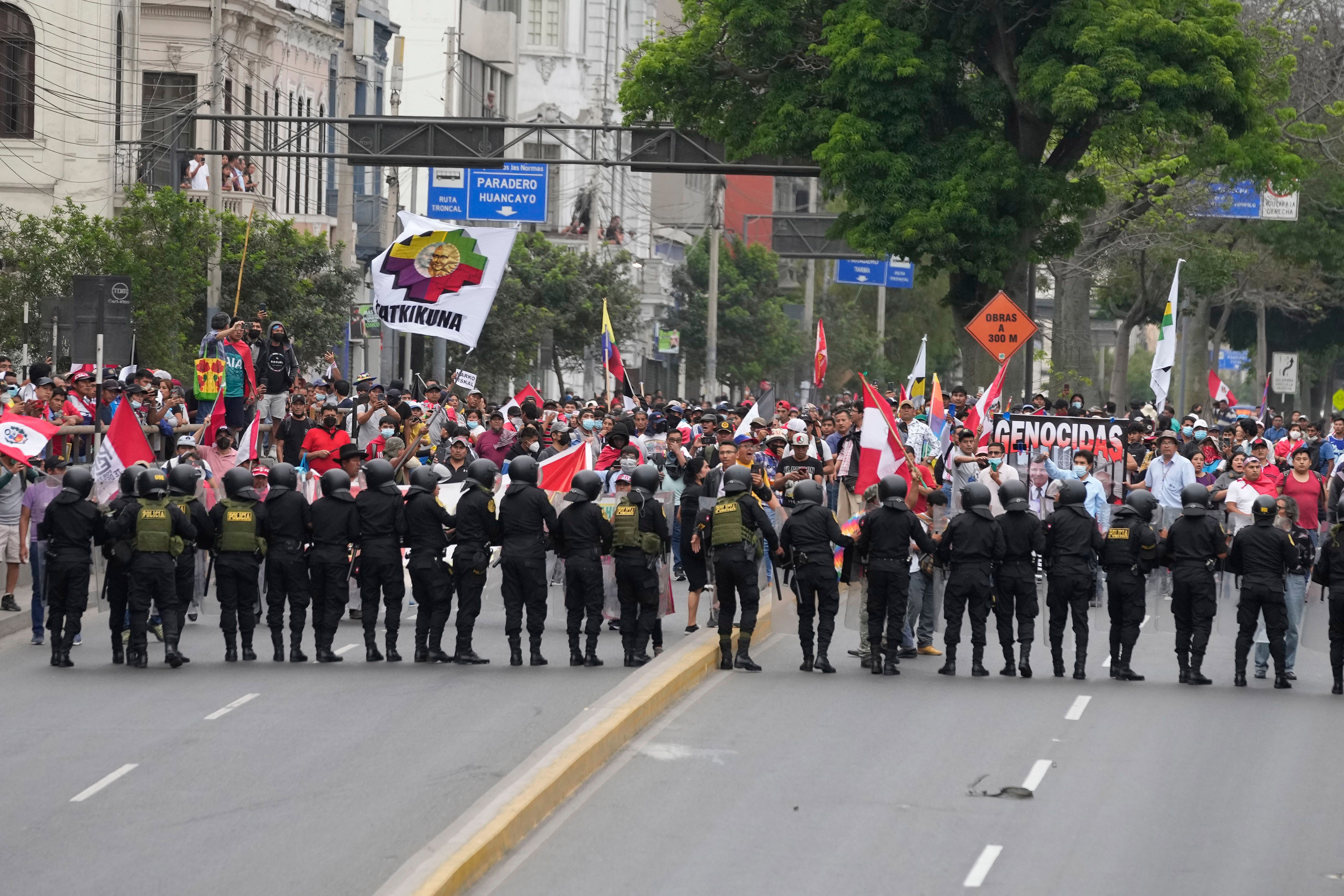 Manifestantes antigobierno que viajaron a la capital desde otras partes del país se enfrentan a una línea de policías antimotines en una marcha contra la presidenta peruana Dina Boluarte en Lima, Perú, el miércoles 18 de enero de 2023. Las protestas buscan un adelanto electoral inmediato, la renuncia de Boluarte, la liberación del presidente destituido Pedro Castillo y justicia por las docenas de manifestantes muertos en enfrentamientos con la policía. (AP Foto/Martín Mejía)