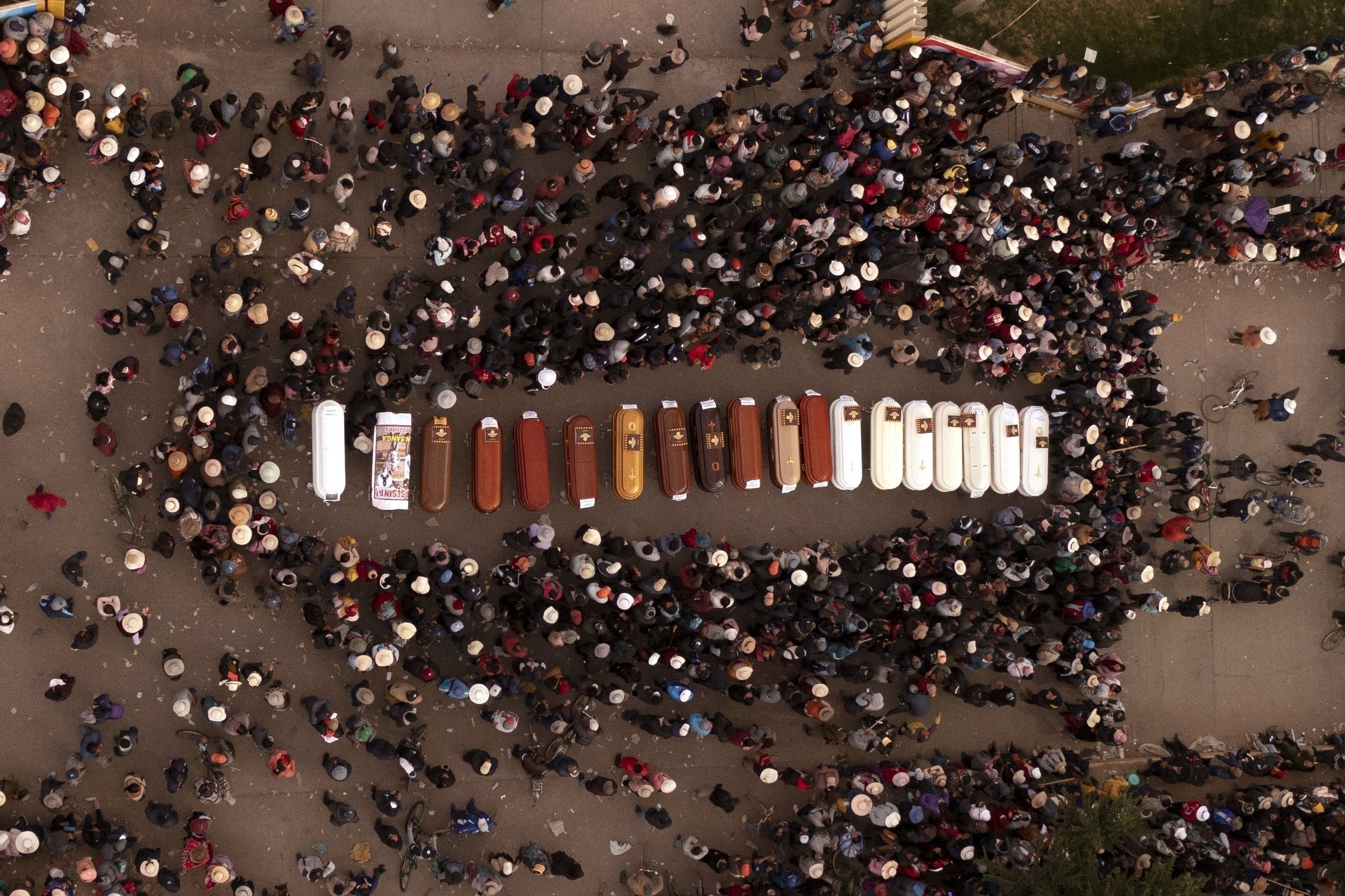 Los residentes rodean ataúdes el martes 10 de enero de 2023 durante una vigilia por la muerte de más de una docena de personas durante los disturbios en Juliaca.