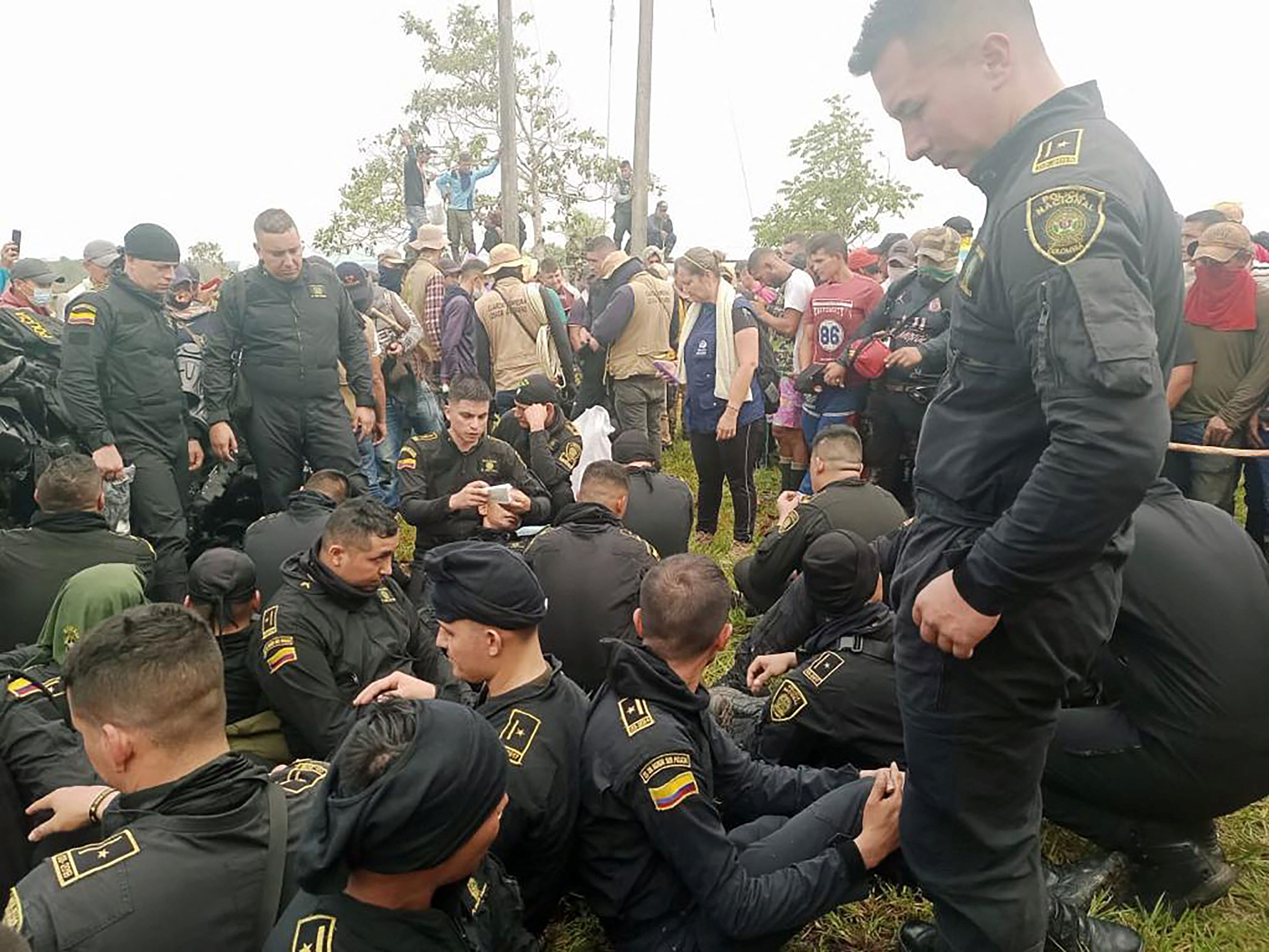 Police sit while officials from Colombia's human rights ombudsman speak with demonstrators who, according to authorities, belong to rural and Indigenous communities and are demanding that oil company Emerald Energy build roads in San Vicente del Caguan, Colombia March 2, 2023. Colombian Ombudsman Office/Handout via REUTERS ATTENTION EDITORS - THIS IMAGE WAS PROVIDED BY A THIRD PARTY. MANDATORY CREDIT. NO RESALES. NO ARCHIVES