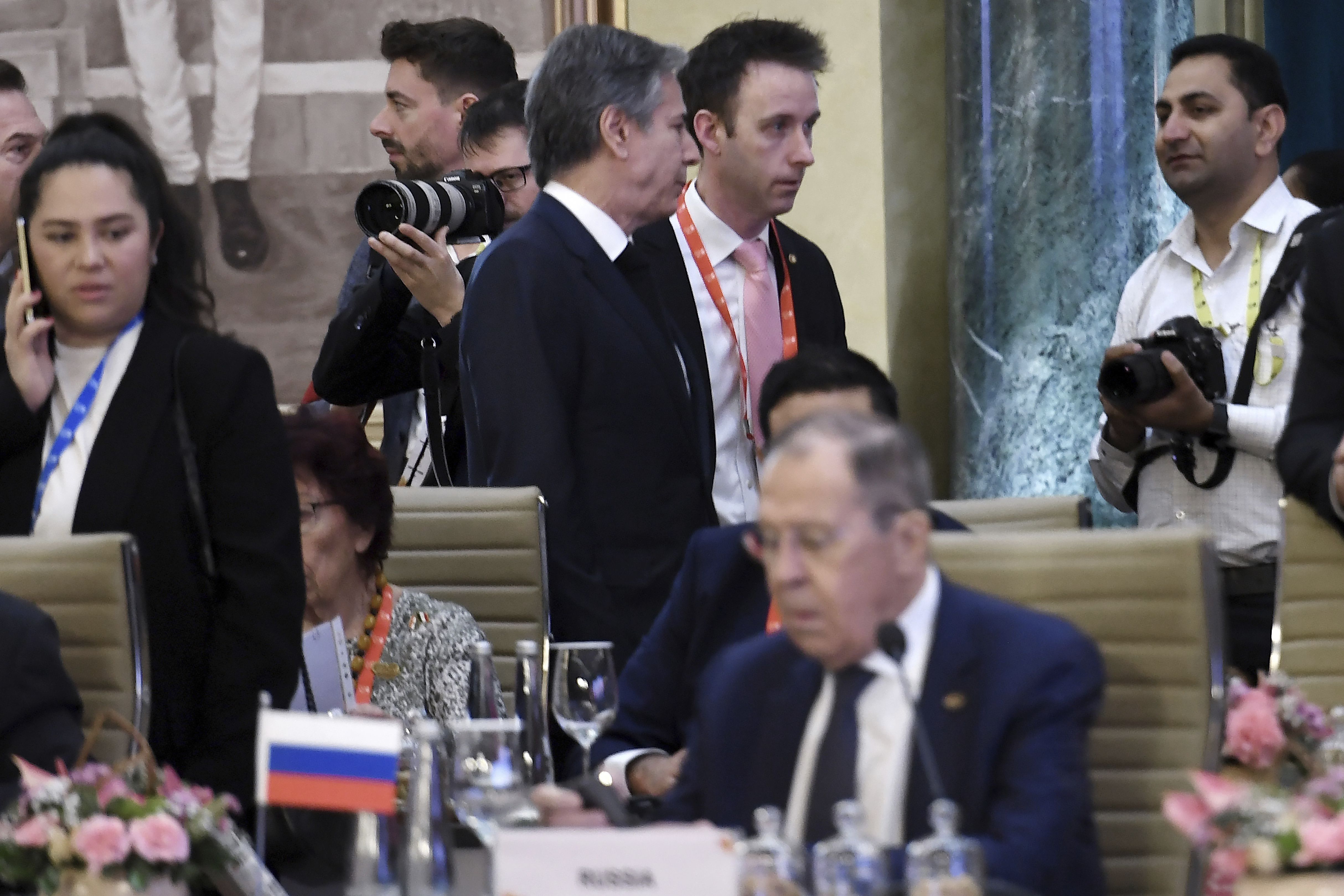 El secretario de Estado de Estados Unidos, Antony Blinken (centro, arriba), pasa junto al ministro de Exteriores de Rusia, Sergéi Lavrov, durante una reunión de cancilleres del Grupo de los 20 en Nueva Delhi, en India, el 2 de marzo de 2023. (Olivier Douliery/Pool Foto vía AP)