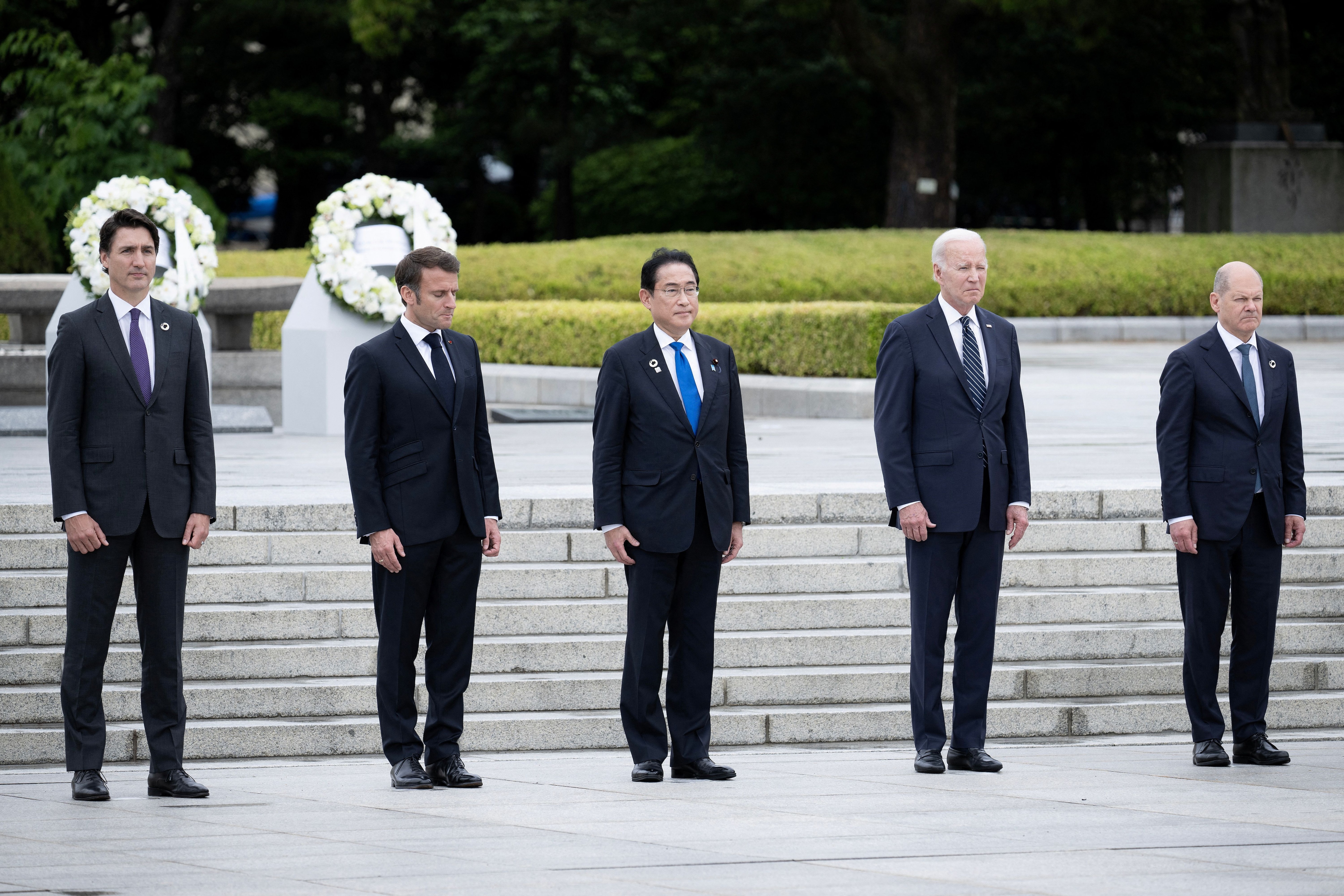 El primer ministro de Canadá, Justin Trudeau, el presidente de Francia, Emmanuel Macron, el primer ministro de Japón, Fumio Kishida, el presidente de Estados Unidos, Joe Biden, y el canciller de Alemania, Olaf Scholz, ante sus coronas de flores durante una visita al Parque Memorial de la Paz en el marco de la Cumbre de Líderes del G7. (REUTERS)