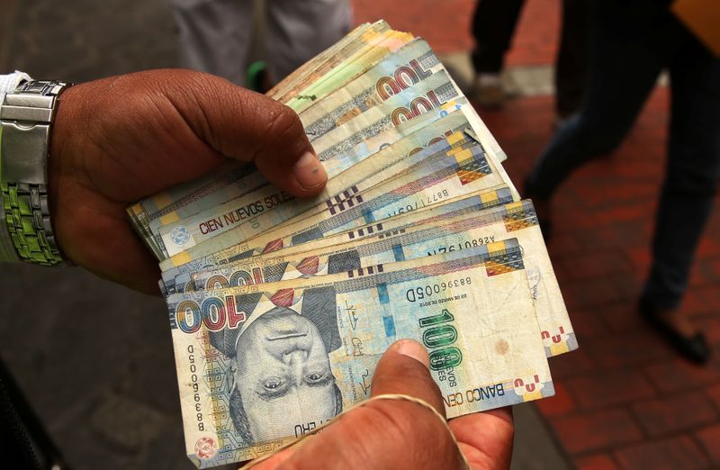 IMAGEN DE ARCHIVO. Un trabajador de una casa de cambio sostiene billetes de soles peruanos en Lima, Perú, Diciembre 15, 2017. REUTERS/Mariana Bazo