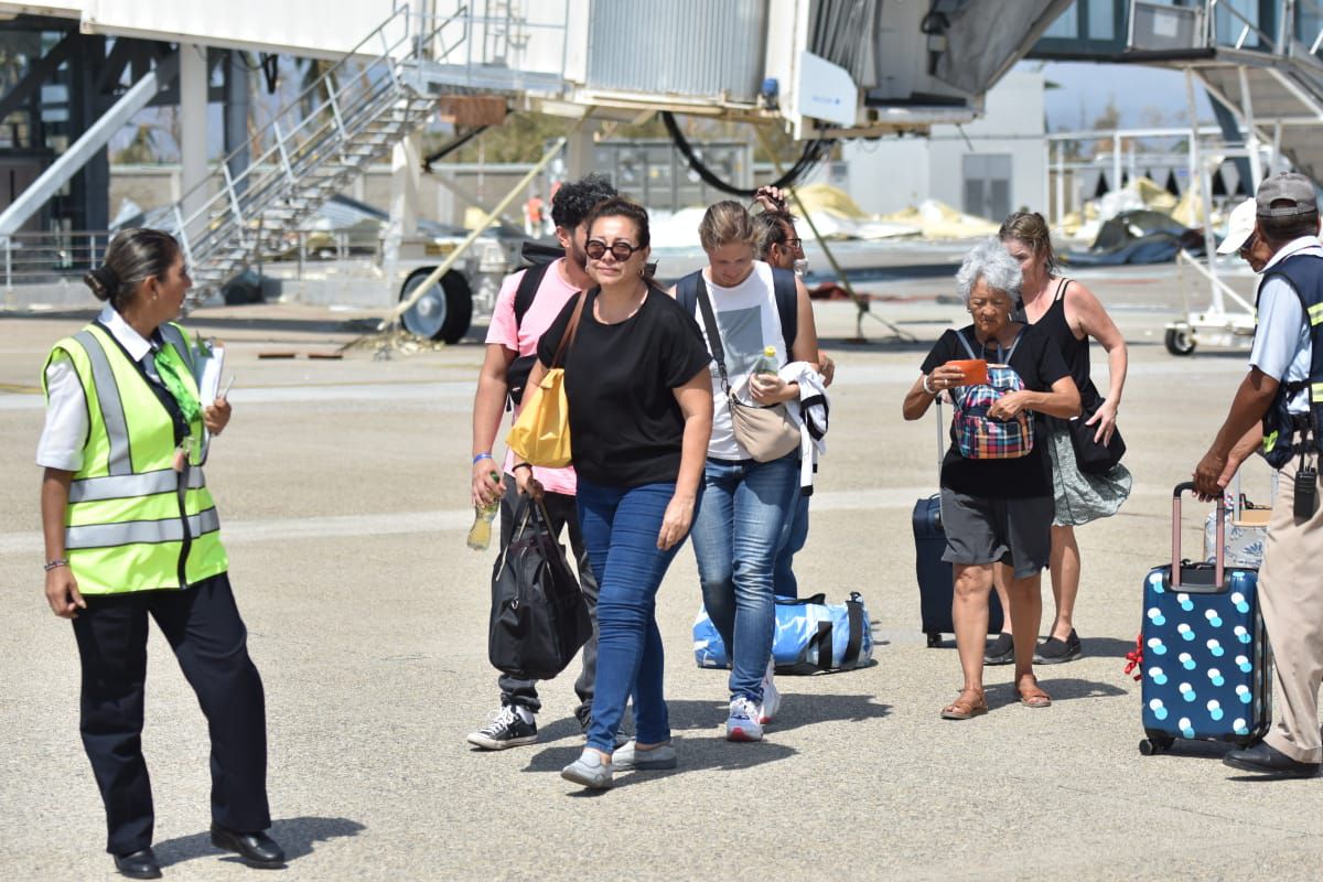 Turistas se preparan para abordar un vuelo para salir de Acapulco tras el paso de Otis