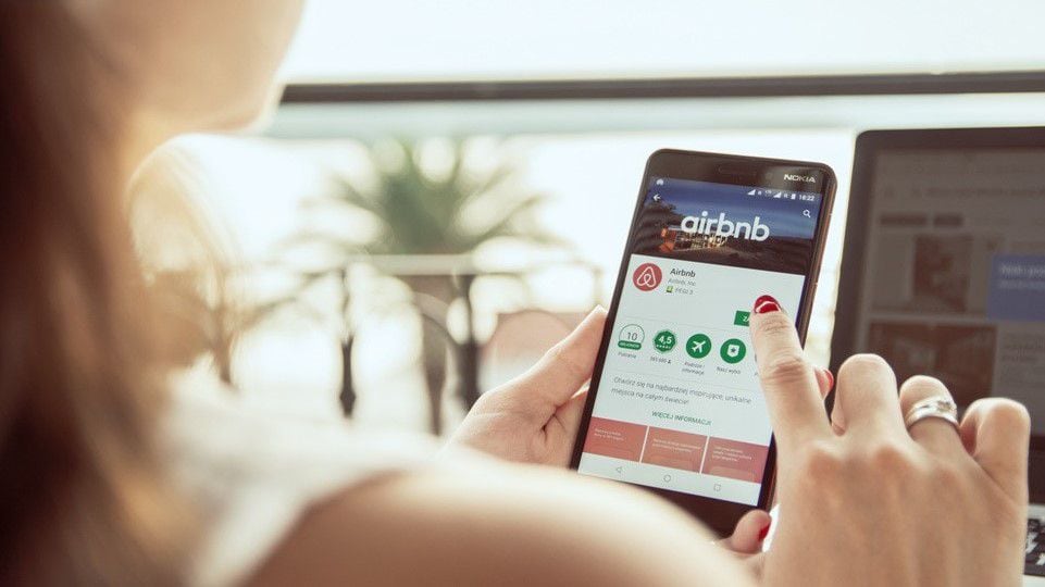 Una joven entra en la página web de Airbnb. (Adobe Stock)