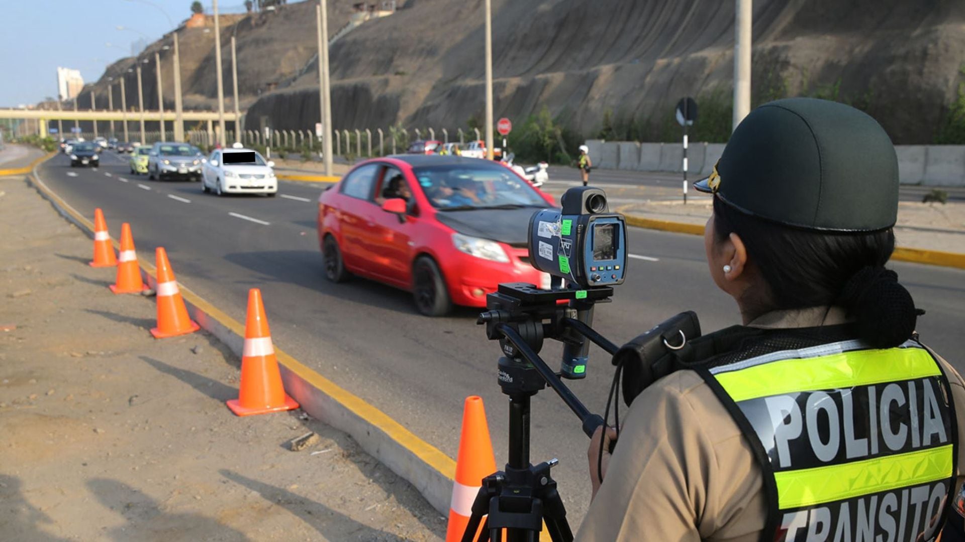 Una policía de la unidad de tránsito se encuentra fiscalizando que los conductores cumplan el reglamento vigente, al circular por el circuito de playas de la Costa Verde.