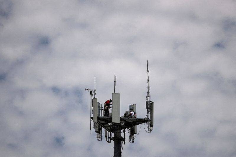 Trabajadores instalan equipos de telecomunicaciones 5G en una torre en Texas, Estados Unidos (Adrees Latif/REUTERS)