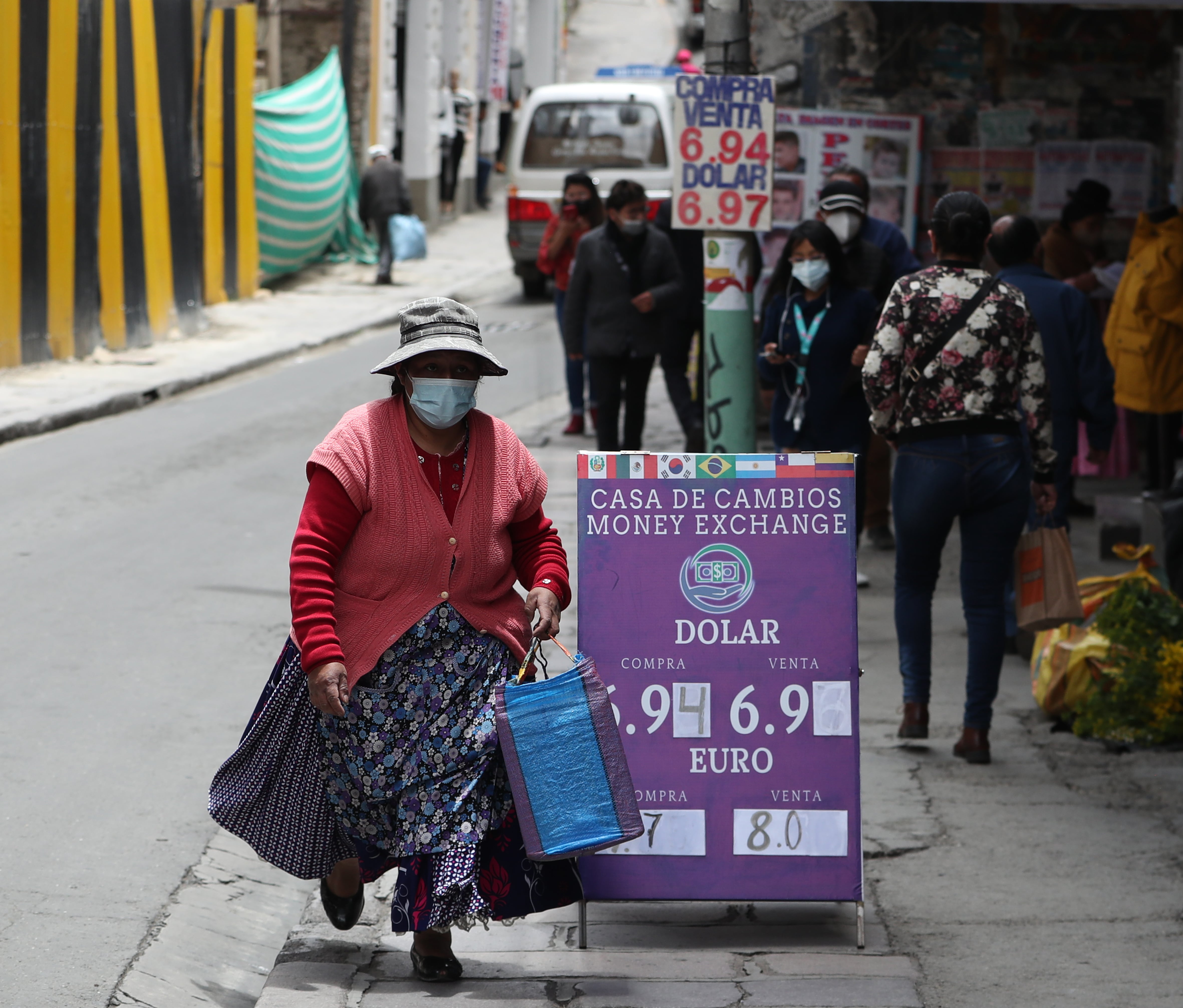 Fotografía de archivo de una mujer aimara caminand frente a una casa de cambio, en La Paz (Bolivia). EFE/Martín Alipaz 